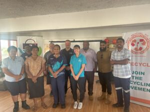 Group photo of Fiji recycling partners and trainers standing with banners promoting the recycling movement.